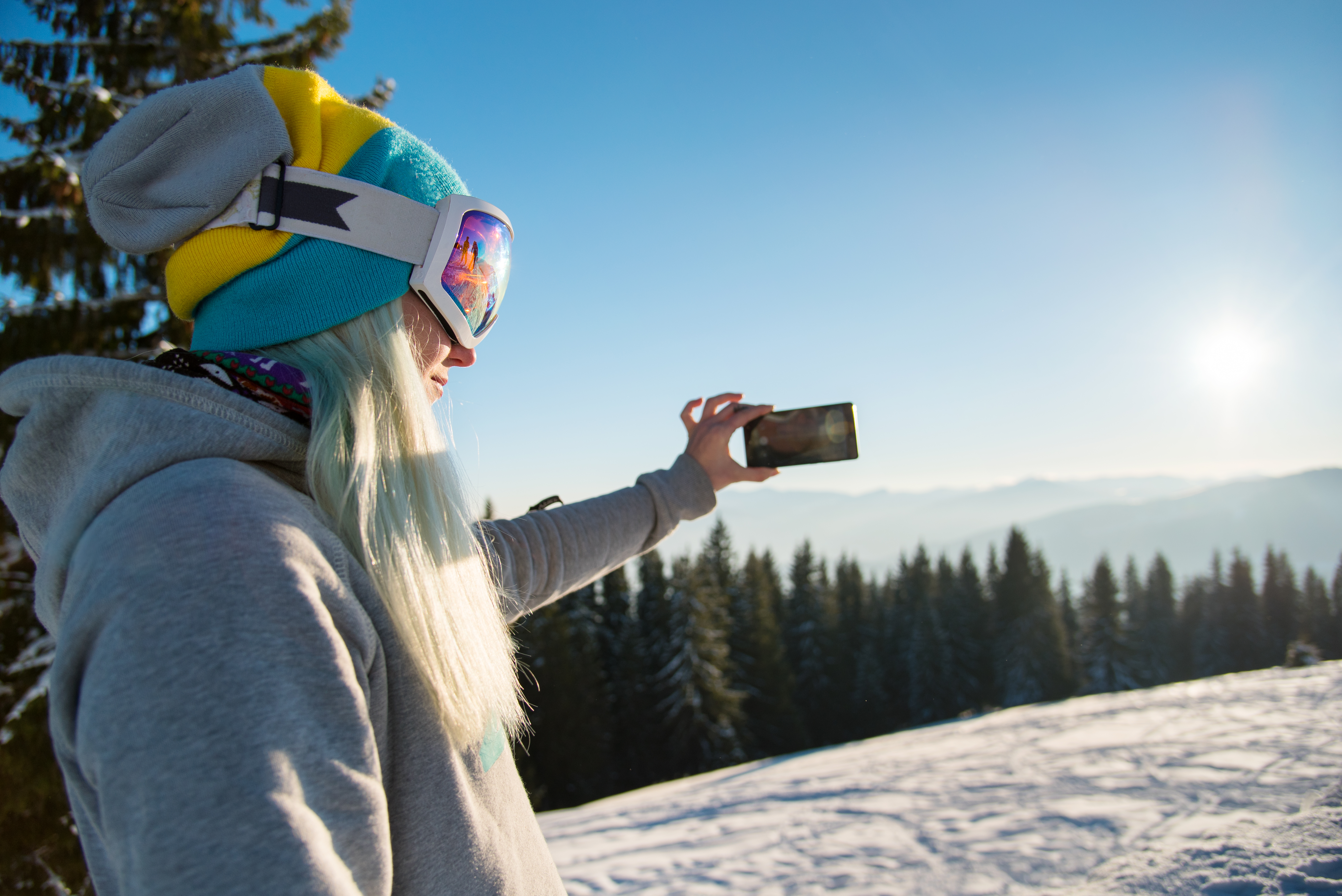 Snowboarder using smart phone in the mountains